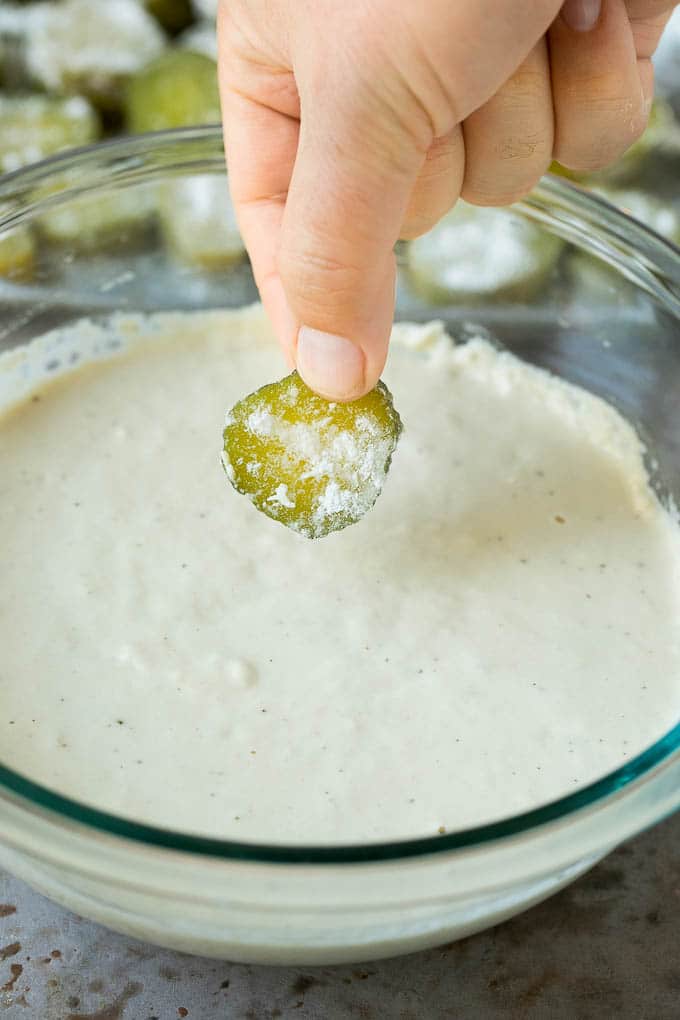 Fried Pickles Recipe #pickles #appetizer #snack #sraye A slice being dipped into a bowl of beer batter.
