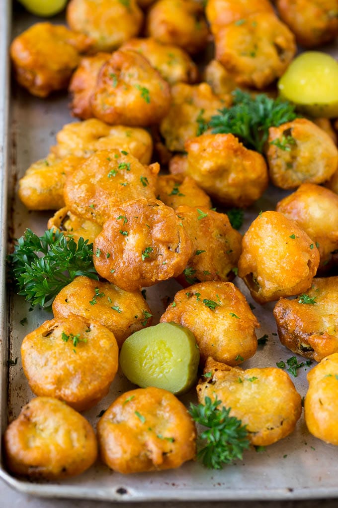 Fried Pickles Recipe #pickles #appetizer #snack #sraye Fried pickles on a sheet pan, garnished with parsley.