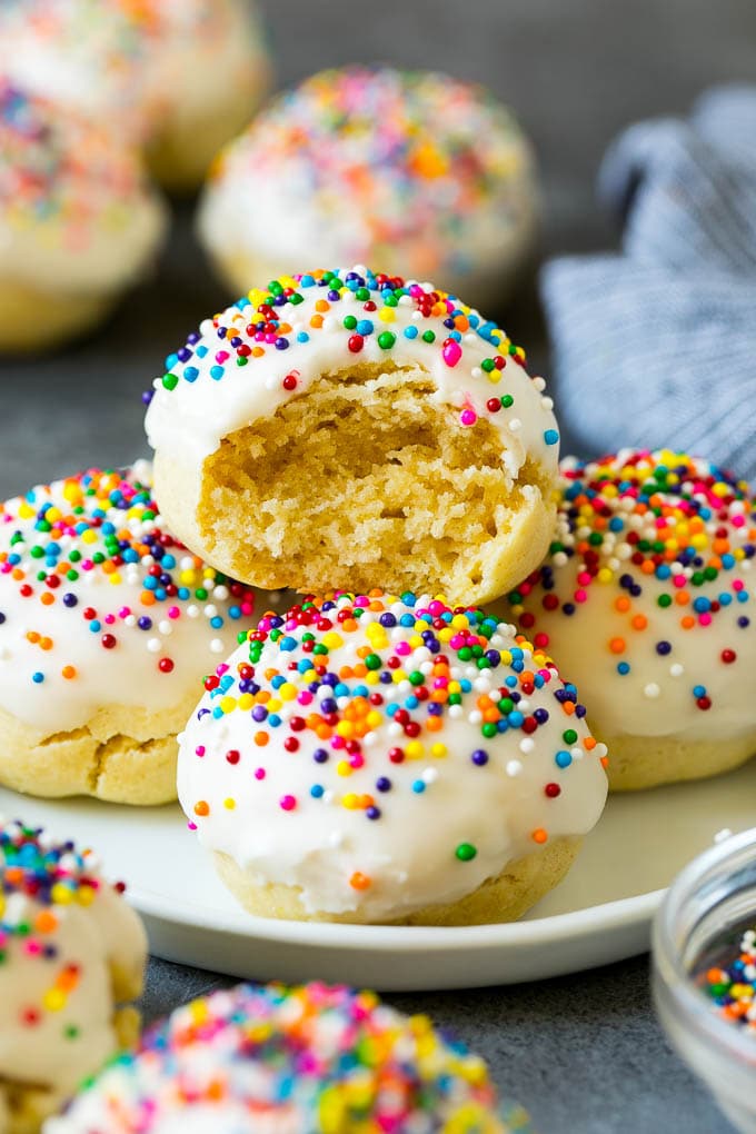 Italian Cookies Recipe | Almond Cookies #cookies #italianfood #frosting #sprinkles #baking #christmas #sraye A plate of Italian cookies with a bite taken out of one.