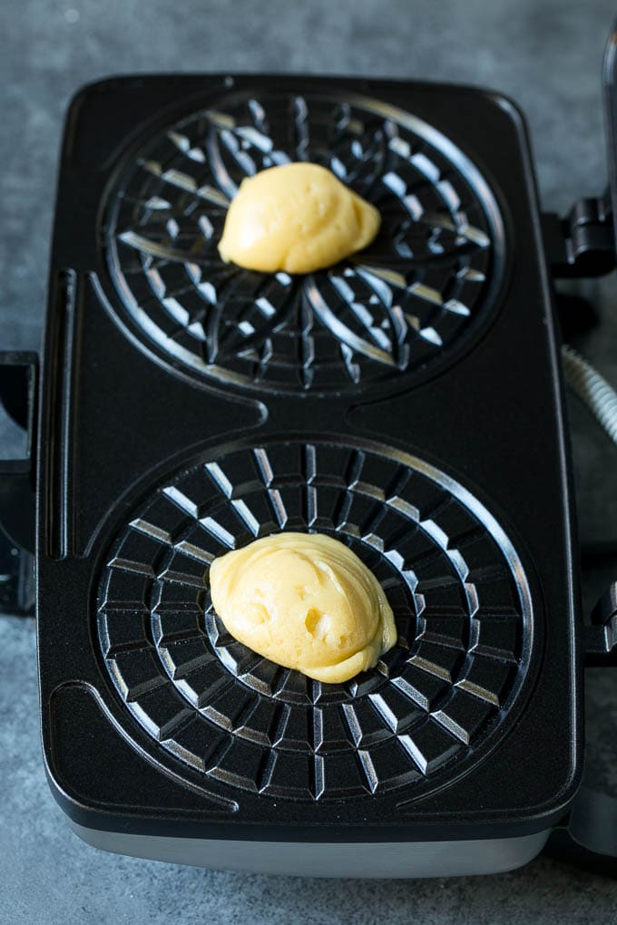 Pizzelle Cookies Recipe #cookies #baking #dessert #christmas #sraye Dollops of dough in a cookie iron.