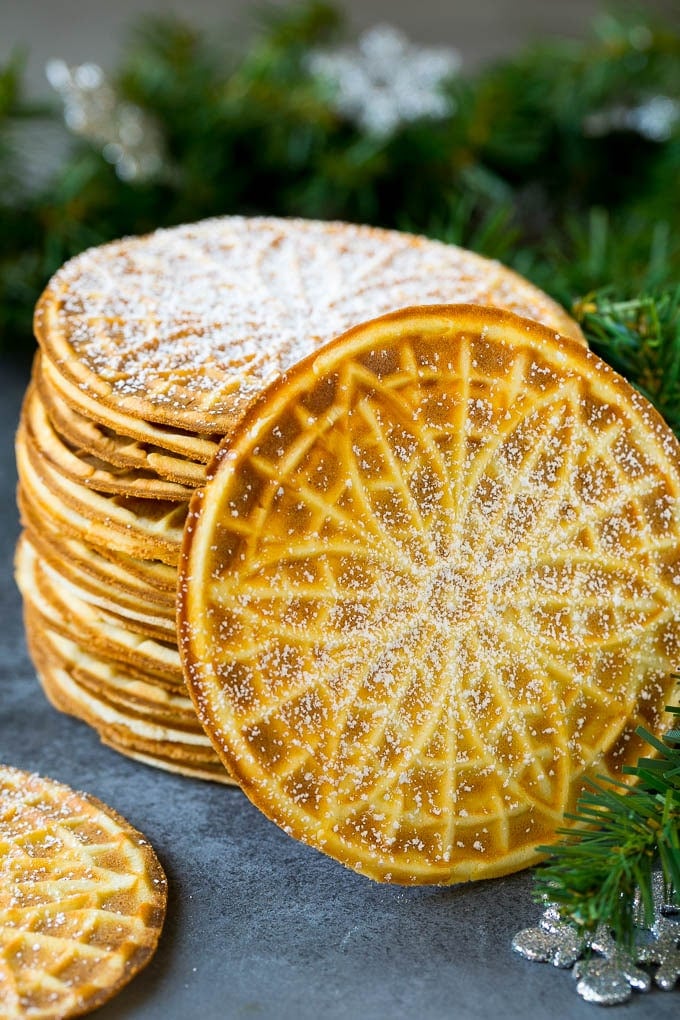 Pizzelle Cookies Recipe #cookies #baking #dessert #christmas #sraye A stack of pizzelle cookies dusted with powdered sugar.
