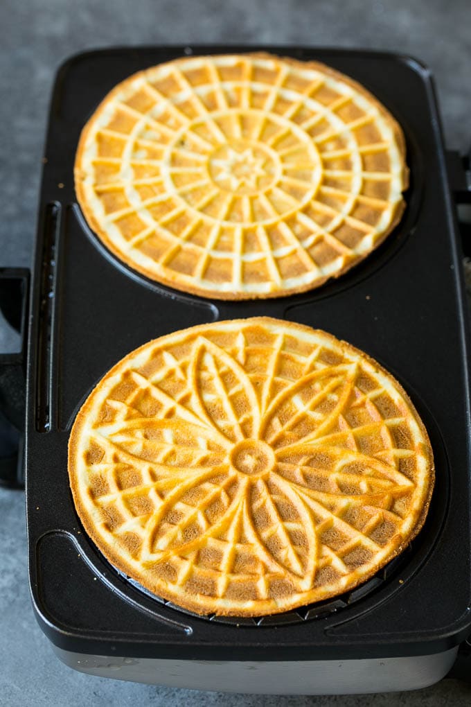 Pizzelle Cookies Recipe #cookies #baking #dessert #christmas #sraye Baked cookies inside a pizzelle iron.