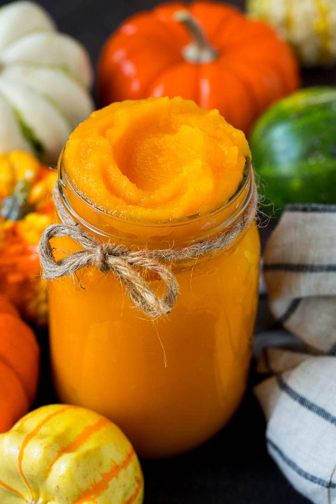 Pumpkin Puree Recipe #pumpkin #baking #fall #thanksgiving #sraye A jar of pumpkin puree surrounded by fall produce.