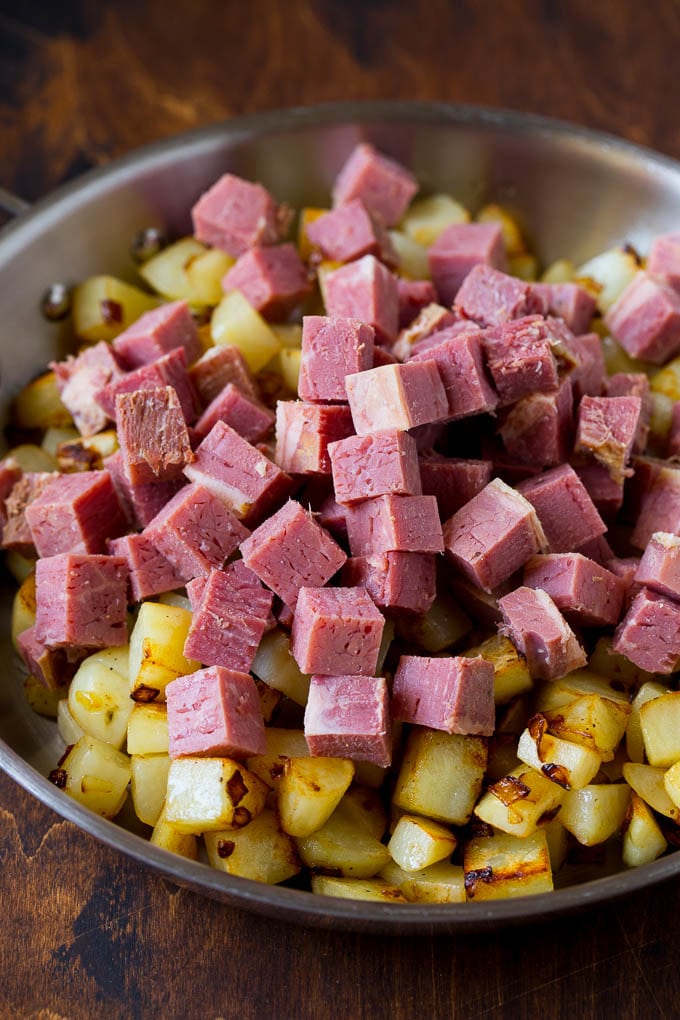 Corned Beef Hash Recipe #hash #cornedbeef #stpatricksday #breakfast #brunch #potatoes #sraye Cubed corn beef on top of cooked potatoes.