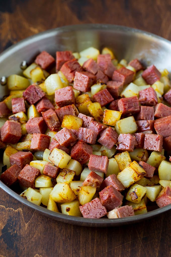 Corned Beef Hash Recipe #hash #cornedbeef #stpatricksday #breakfast #brunch #potatoes #sraye Corned beef and potatoes cooked together in a pan.