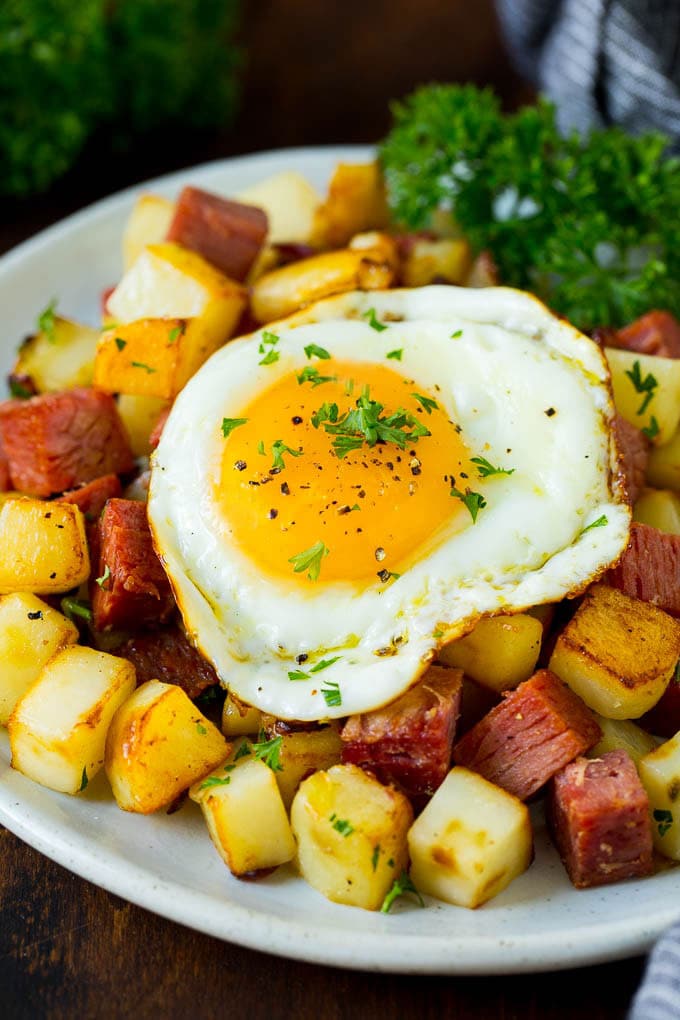 Corned Beef Hash Recipe #hash #cornedbeef #stpatricksday #breakfast #brunch #potatoes #sraye A plate of corned beef hash topped with a fried egg.