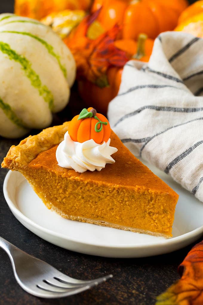 Homemade Pumpkin Pie Recipe | Pumpkin Pie #pie #pumpkin #baking #thanksgiving #fall #dessert #sraye A slice of homemade pumpkin pie topped with whipped cream and a candy pumpkin.