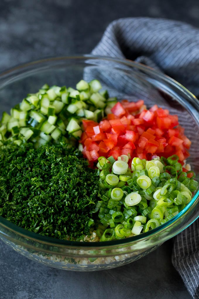 Tabbouleh Salad | Tabouli #salad #wheat #tomatoes #cucumber #healthy #sidedish #dinner #sraye A bowl of bulgur topped with herbs, tomatoes and cucumber.
