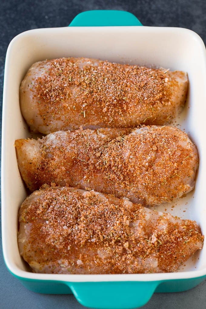 Baked Chicken Breast Recipe #chicken #dinner #sraye Chicken coated in seasonings in a baking dish.