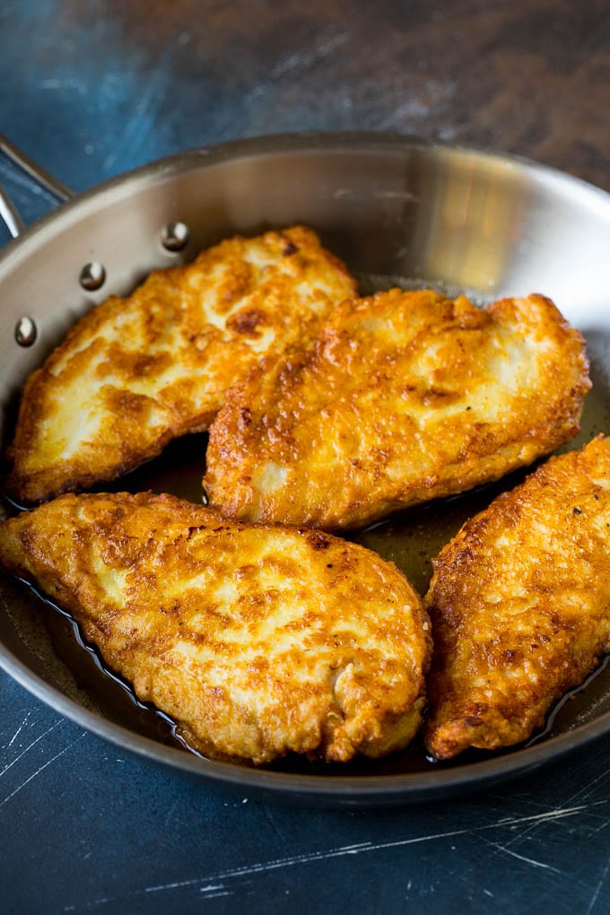 Chicken Francese Recipe #chicken #lemon #dinner #sraye Battered and pan fried chicken cutlets in a pan.