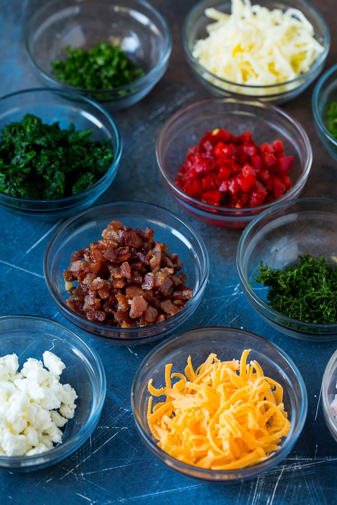 Mini Quiche Recipe #eggs #breakfast #brunch #appetizer #sraye Bowls of assorted flavorings for quiche.