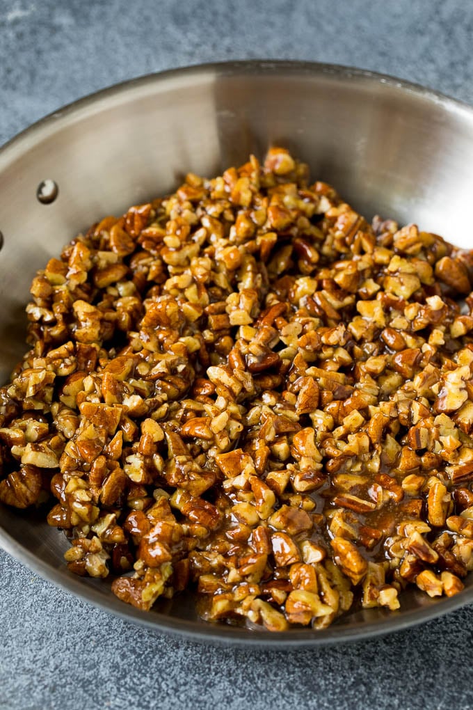 This pecan pie cheesecake is a creamy brown sugar cheesecake topped with a rich and decadent pecan sauce. Pecan brown sugar topping in a skillet.