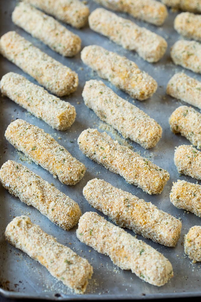 Mozzarella Sticks Recipe #cheese #appetizer #sraye Breaded cheese on a baking pan.