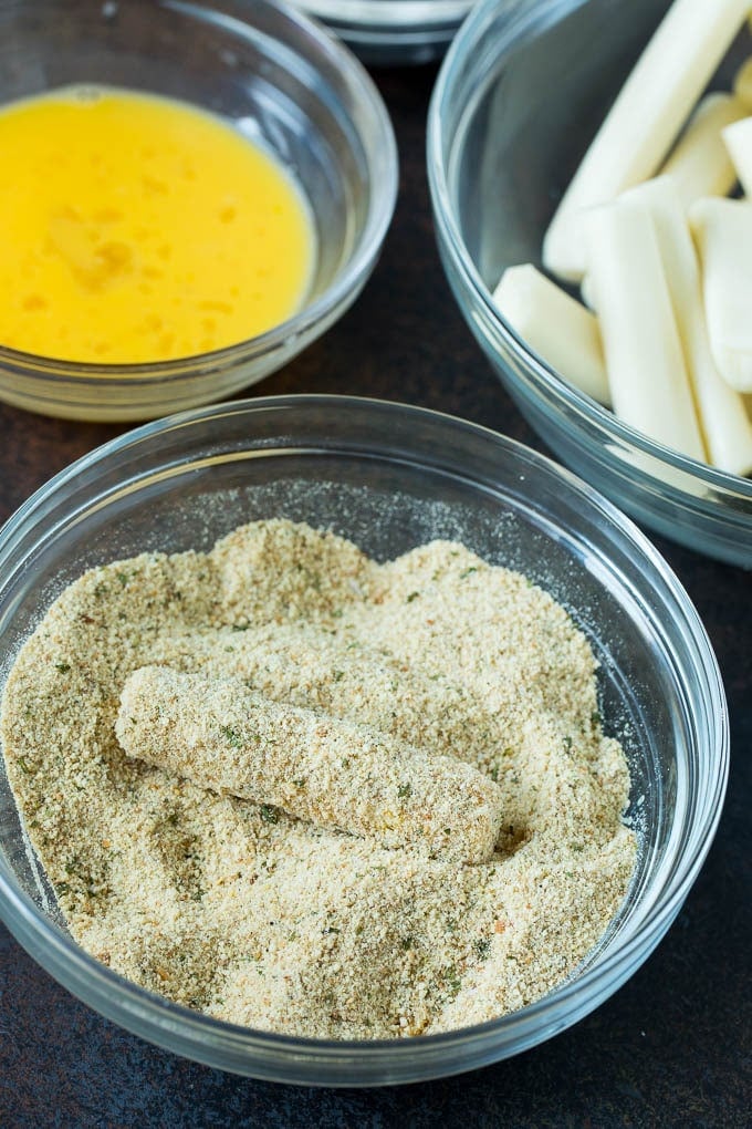 Mozzarella Sticks Recipe #cheese #appetizer #sraye Cheese in a bowl of seasoned breadcrumbs.