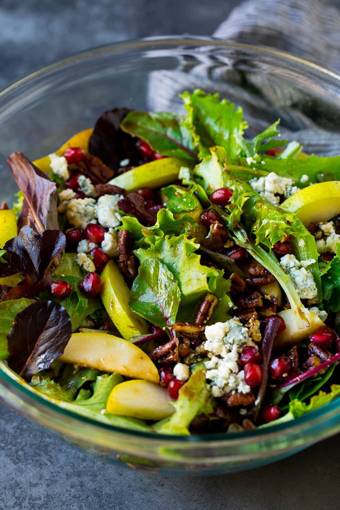 Pear Salad Recipe #salad #pears #fall #winter #dinner #sraye A bowl of pear salad with pomegranate, blue cheese and candied pecans.