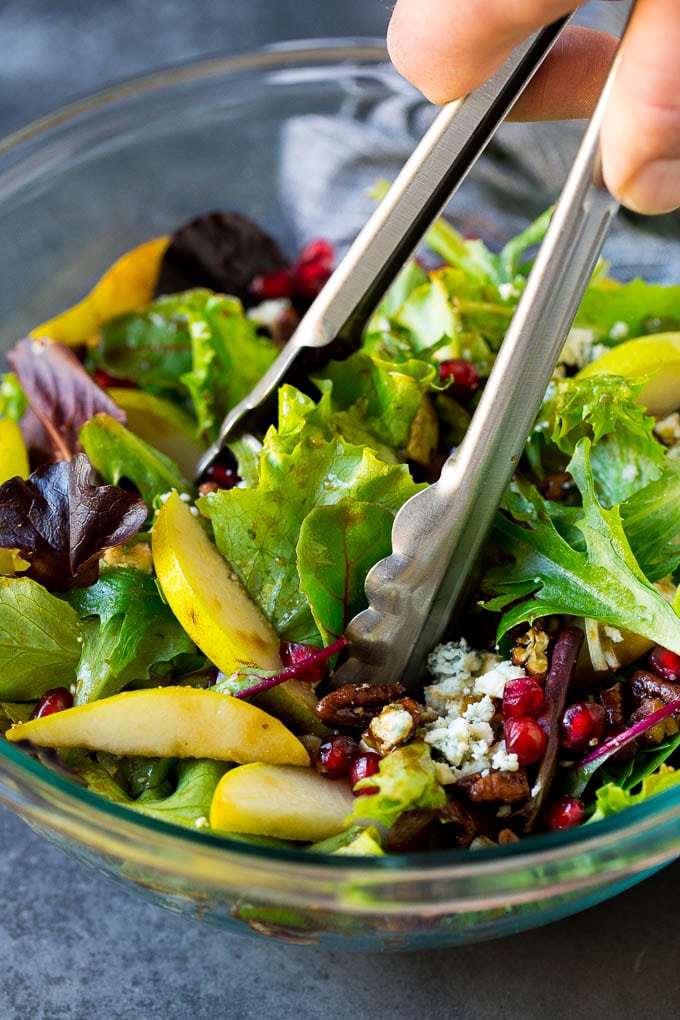 Pear Salad Recipe #salad #pears #fall #winter #dinner #sraye Tongs serving up a portion of pear salad.
