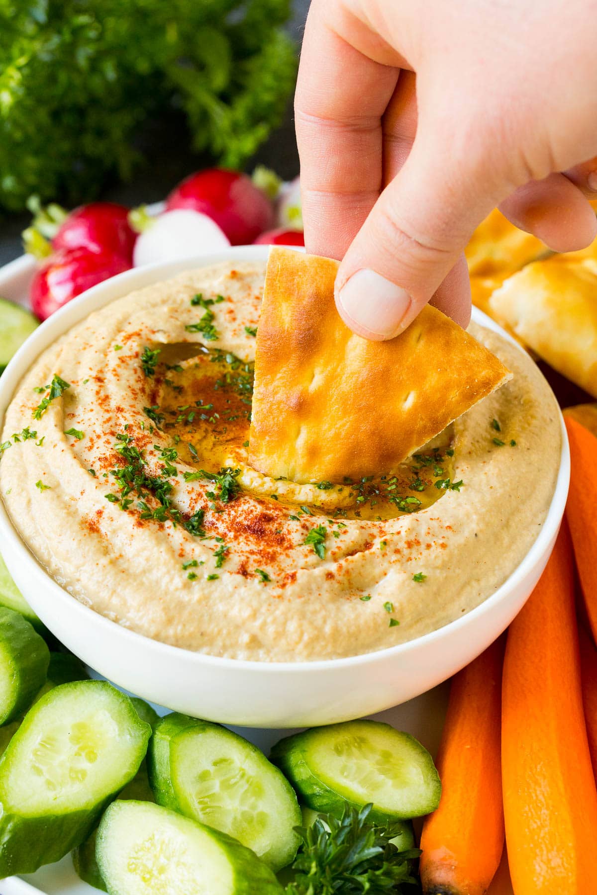 Baba Ganoush Recipe | Eggplant Dip #eggplant #appetizer #dip #healthy #glutenfree #lowcarb #sraye A hand dipping pita bread into baba ganoush.