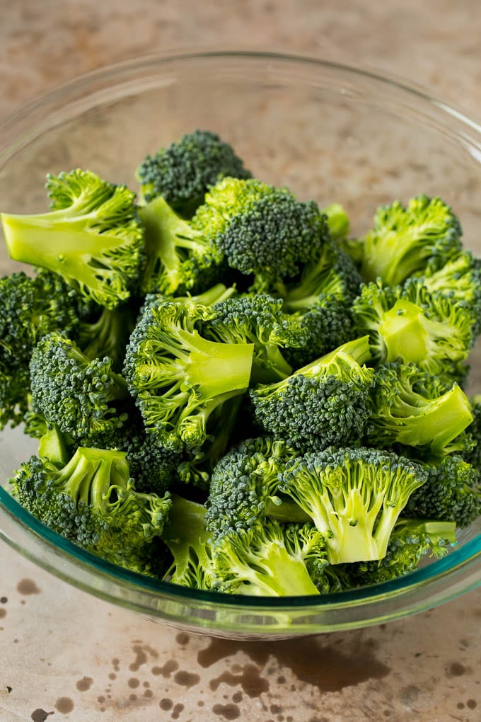 Grilled broccoli is packed with flavor and is a colorful and healthy side dish! #broccoli #sraye Green florets in a bowl.