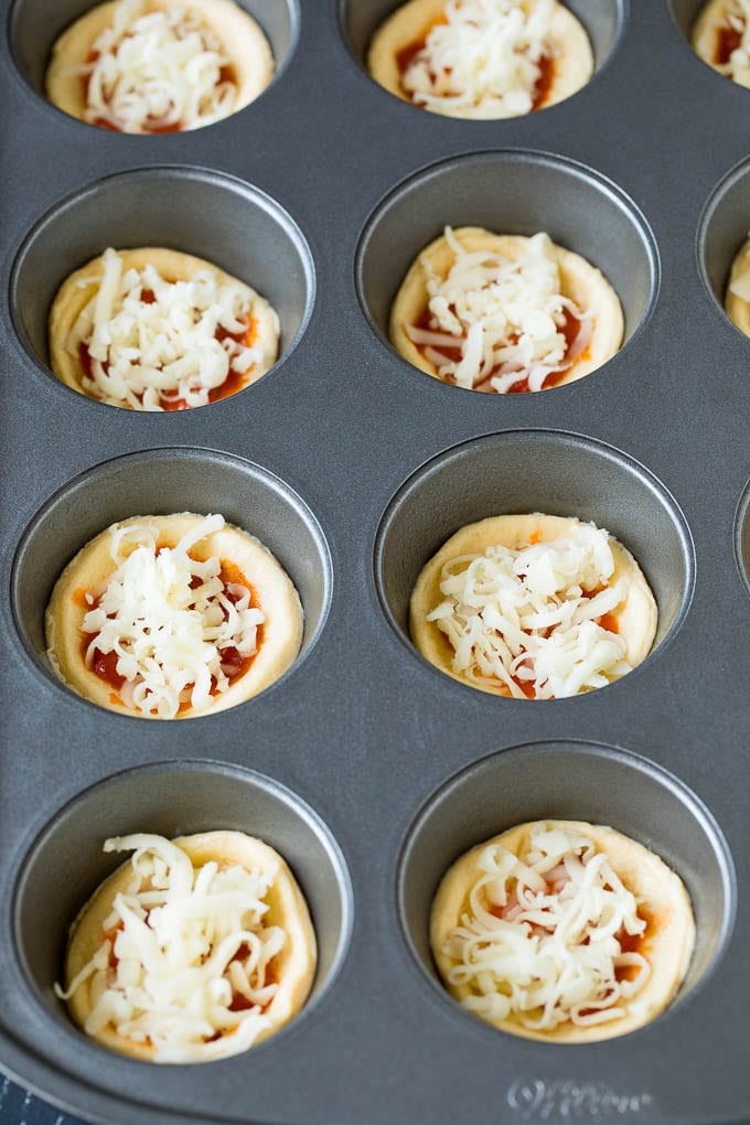 Mini pizzas topped with pepperoni are a fun and easy appetizer option. #pizza #sraye #appetizer Circles of dough topped with pizza sauce and shredded cheese.