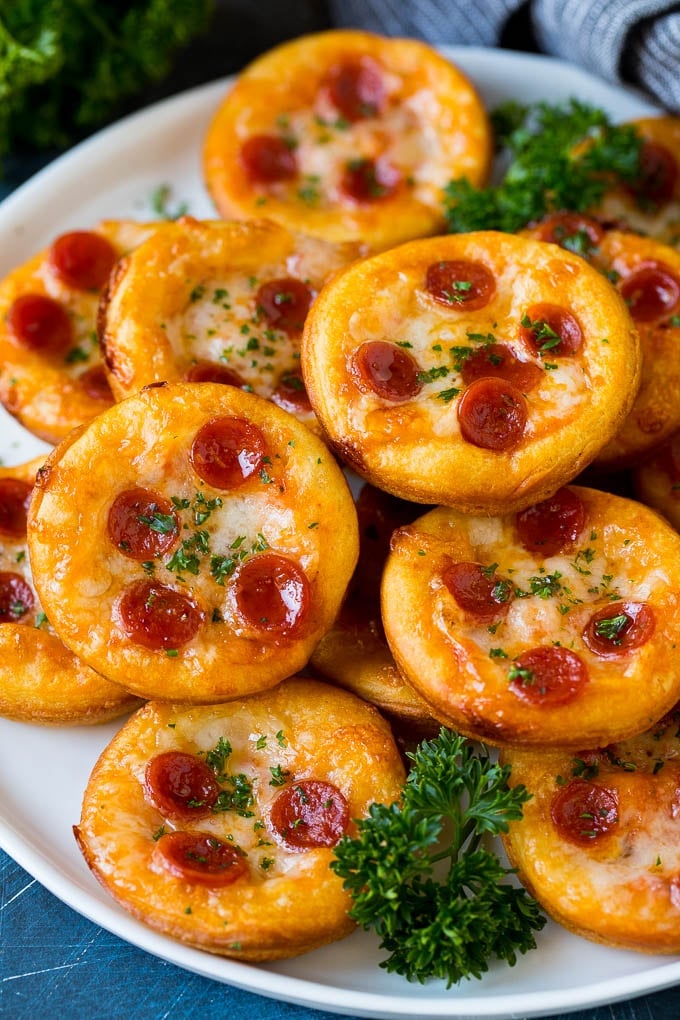 Mini pizzas topped with pepperoni are a fun and easy appetizer option. #pizza #sraye #appetizer Mini pizzas topped with melted cheese and pepperoni.