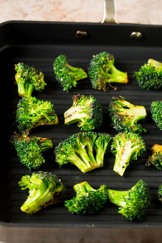 Grilled broccoli is packed with flavor and is a colorful and healthy side dish! #broccoli #sraye Broccoli florets on a grill pan.