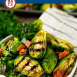 A bowl of balsamic brussels sprouts which are roasted and topped with crispy bacon, and drizzled with a sweet balsamic glaze.