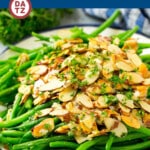 A plate of green beans almondine garnished with parsley.